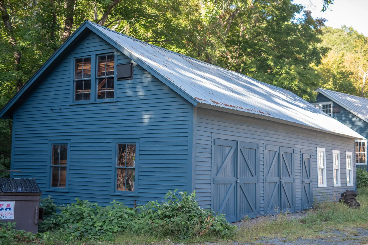 Blue barn-style building with white trim and a metal roof